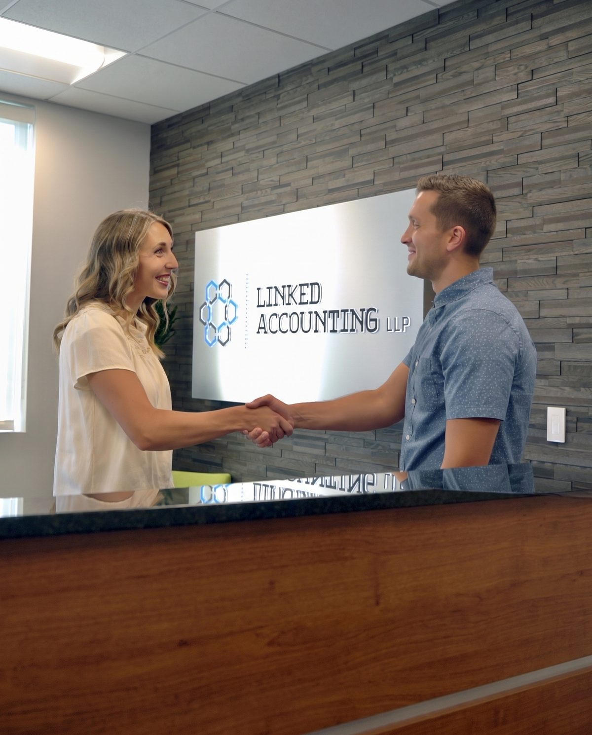 Two members of the Linked Accounting team greeting each other in the office